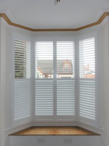 Tall white bay window shutter