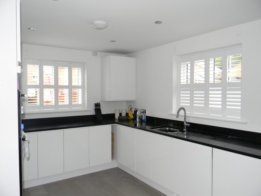 White gloss kitchen with white shutters