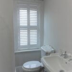 Bathroom with tall window shutter