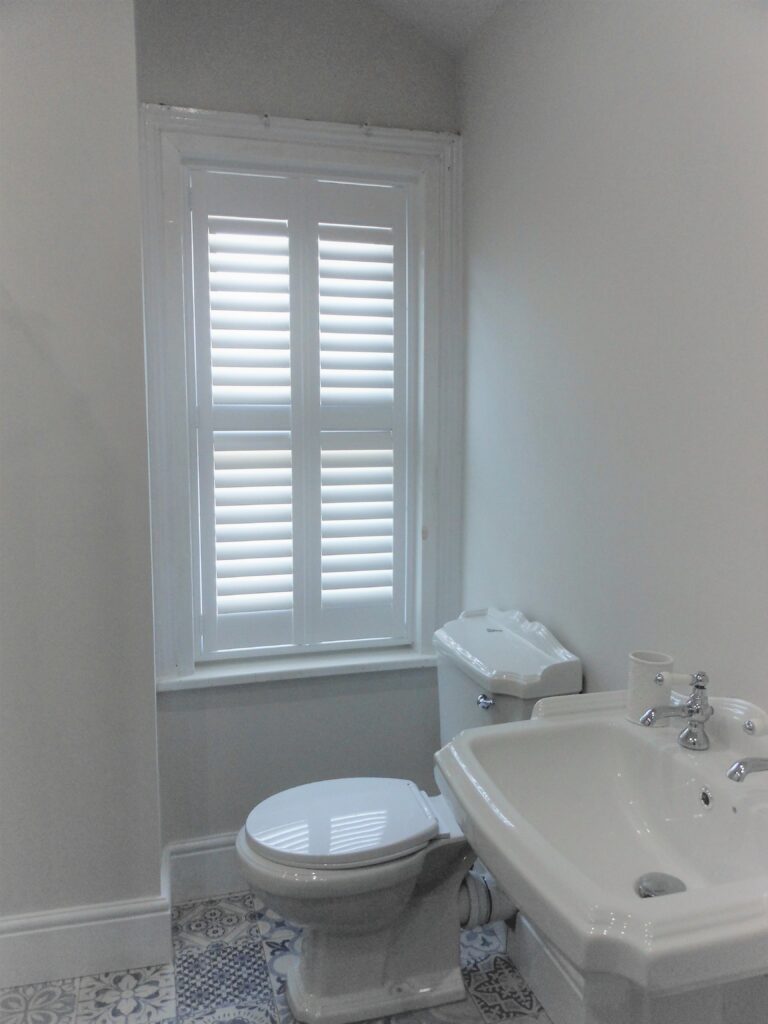 Bathroom with tall window shutter