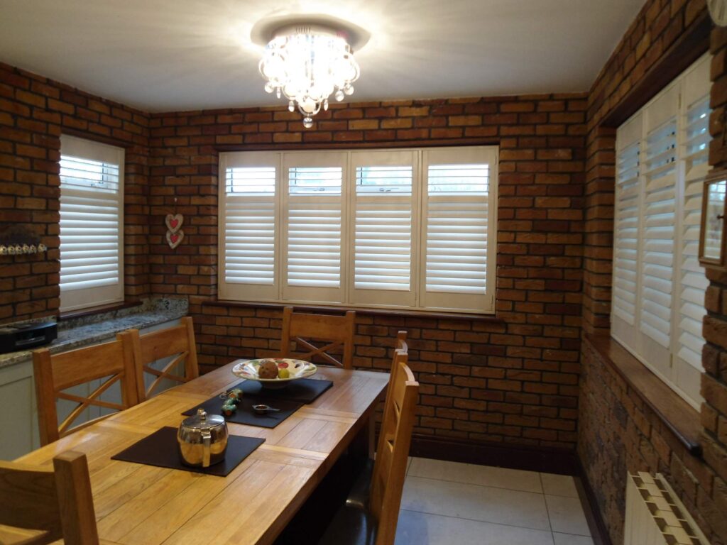 Brick walled dining room with white shutter