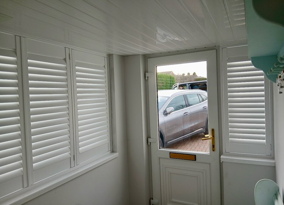 shutters in a porch. White pvc shutters covering a long window