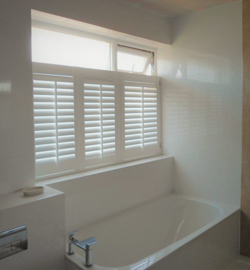 Stone bathroom with white cafe shutter