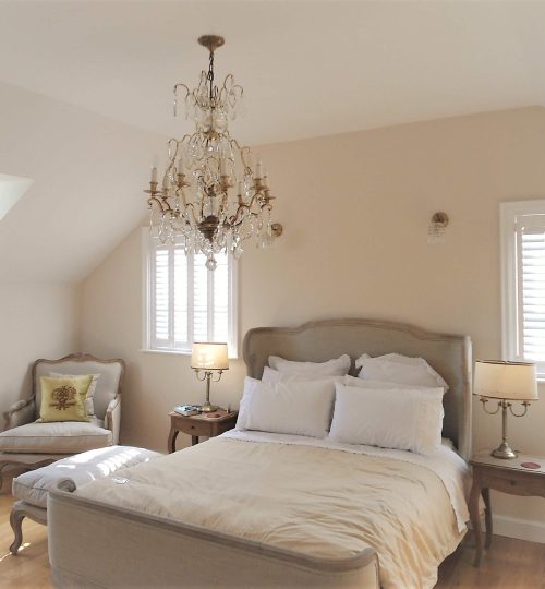 Bedroom with three windows, each with white closed shutters