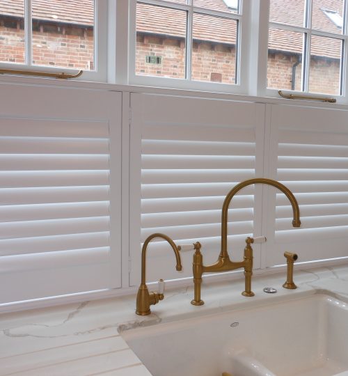 Brass taps in front of a white cafe shutter
