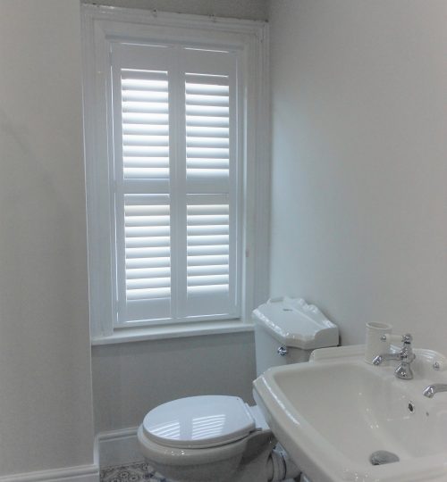 Bathroom with tall window shutter