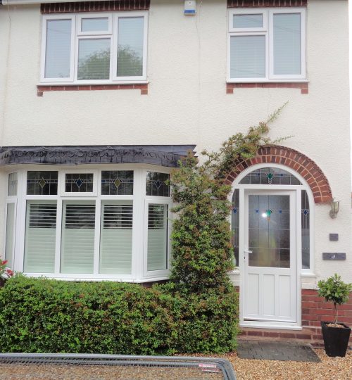 traditional english home with white bay window shutters