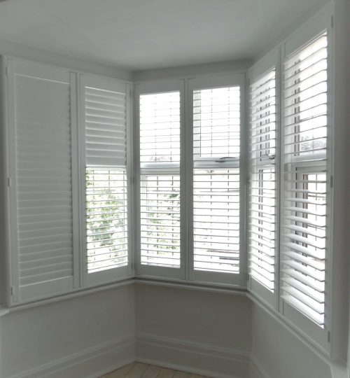 White lounge bay window with shutters half open